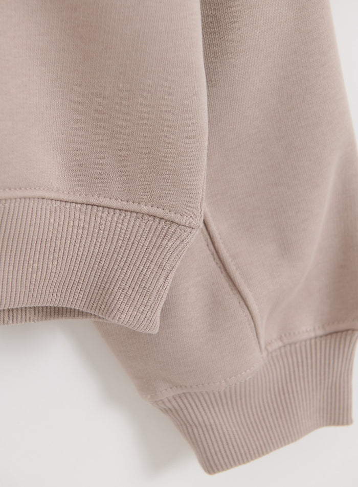 Soft jersey fabric and ribbed cuffs on the Dark Clay Varsity Sweat Half Zip by aim'n.