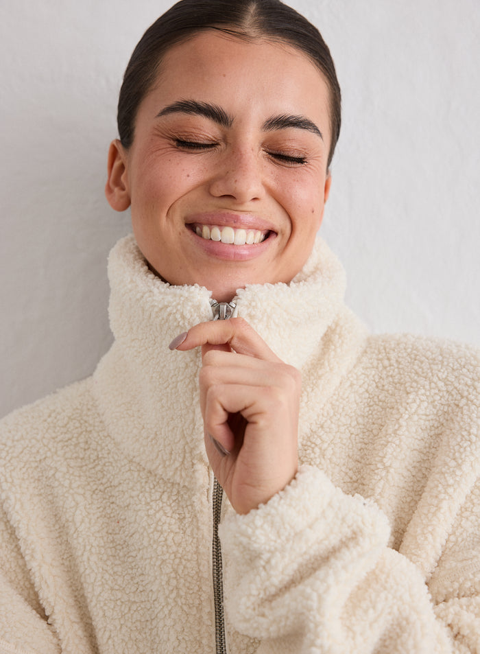 Close-up of a smiling woman wearing an almond white Pile Jacket by aim'n [M-174cm]
