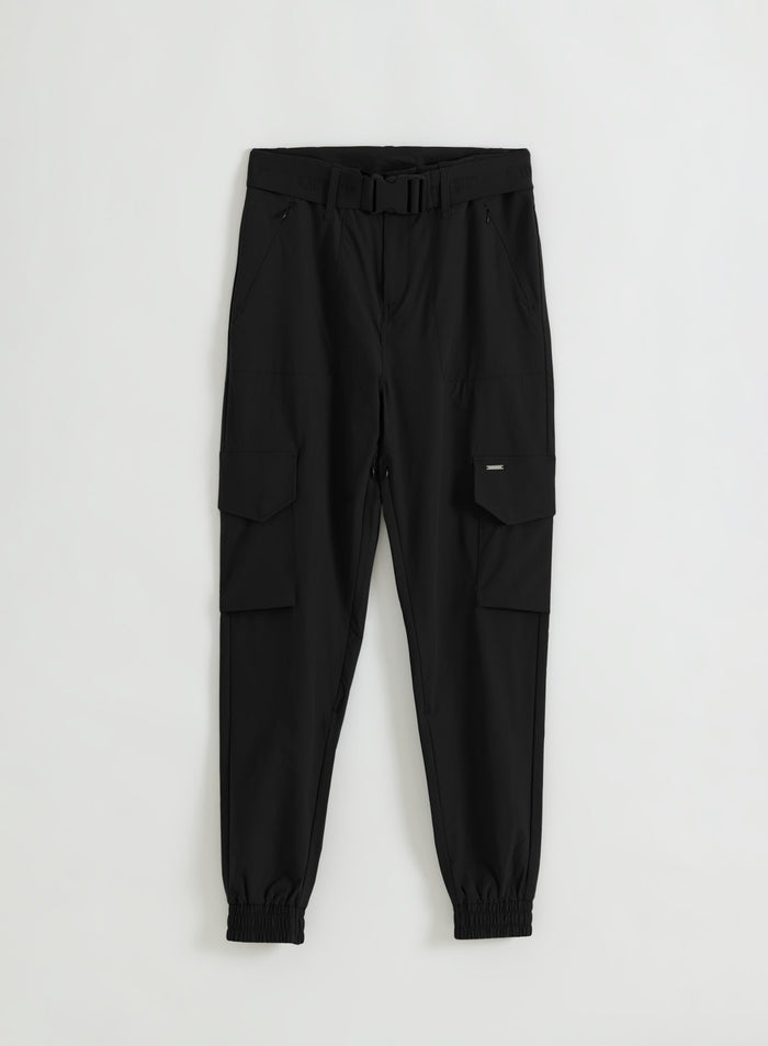 Flat lay of black cargo pants with an elasticated belt, zipped hand pockets, cargo pockets and tapered legs