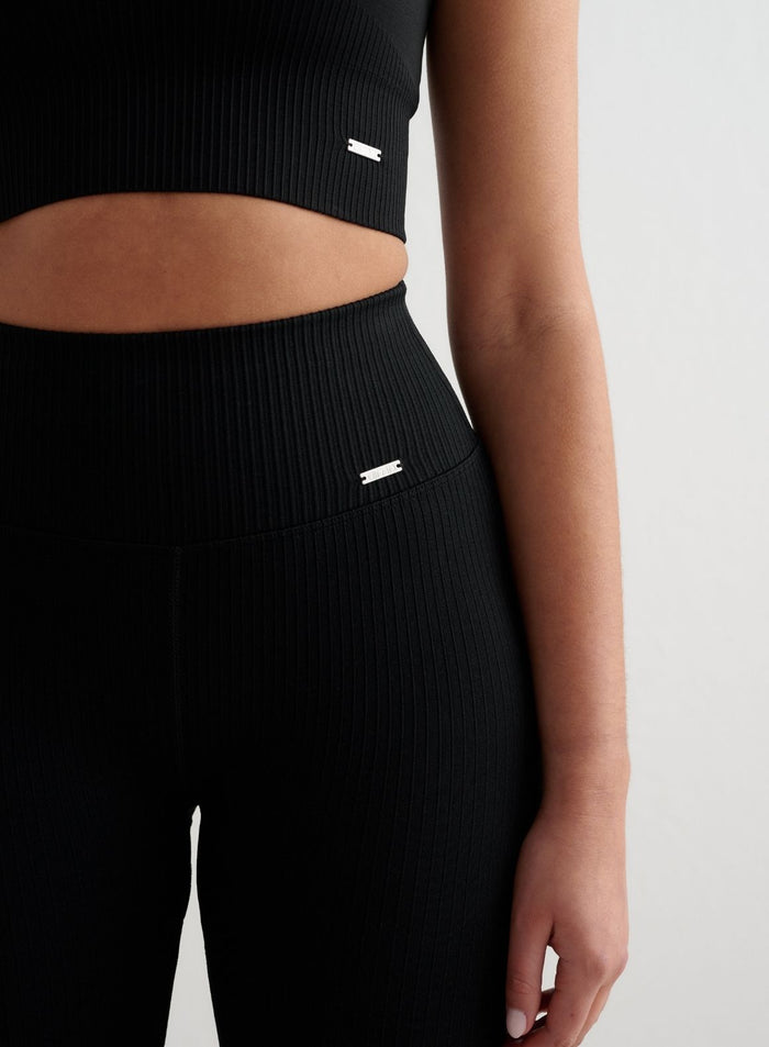 Black high-waisted ribbed seamless flare tights and matching top with silver aim'n logo.