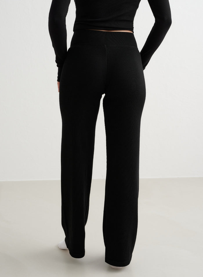 Black high-waisted Ribbed Wool Wide Pants by aim'n shown from the back. [XS - 170 cm]