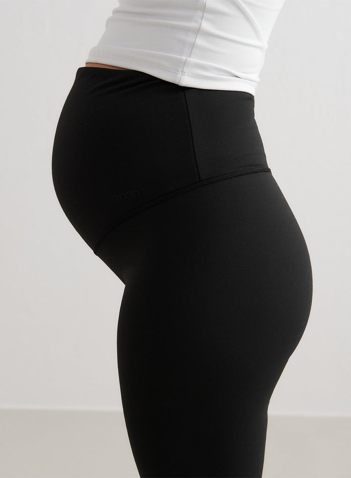 Black aim'n Sense Maternity Flare Tights with a high waistband covering the baby bump for support.