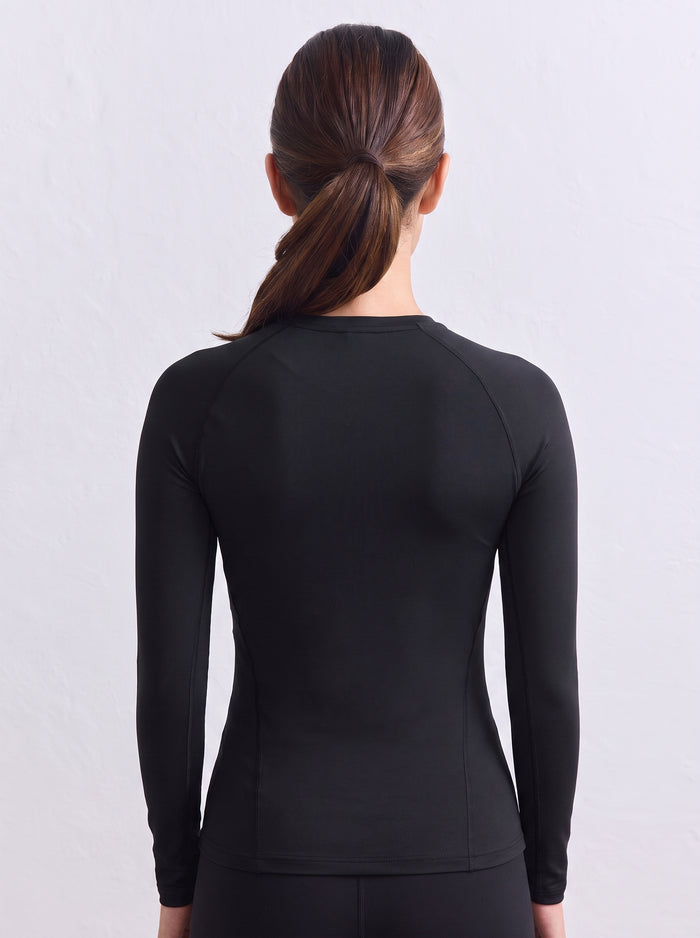 Back view of a model wearing the black aim'n Soft Basic Long Sleeve