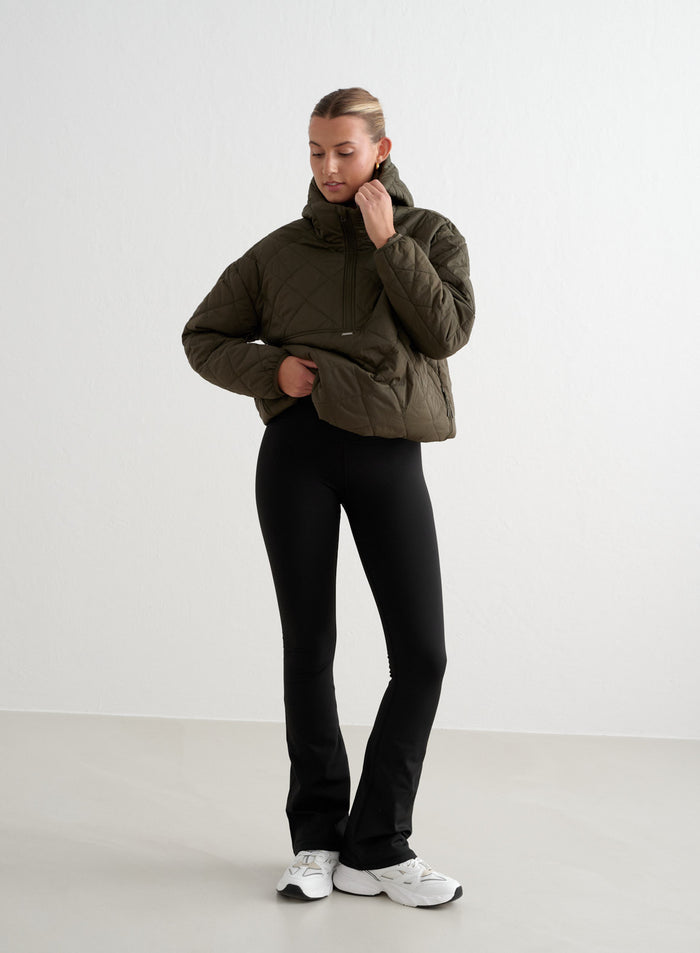 Black high-waisted Warming Flare Tights paired with a khaki quilted jacket. [S-175cm]